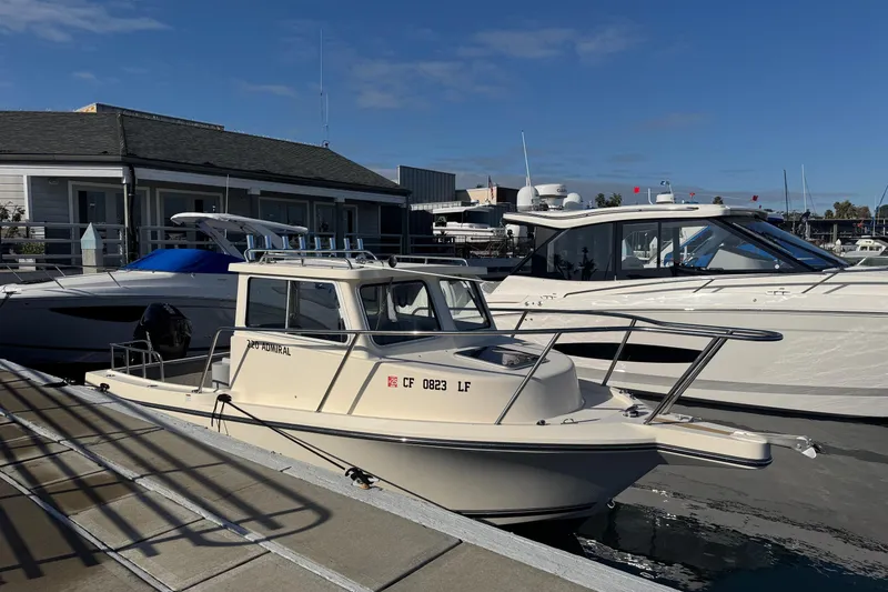 Slide: The Image of 2023 Defiance Admiral 220 EX boat docked at marina under clear blue sky. - 8