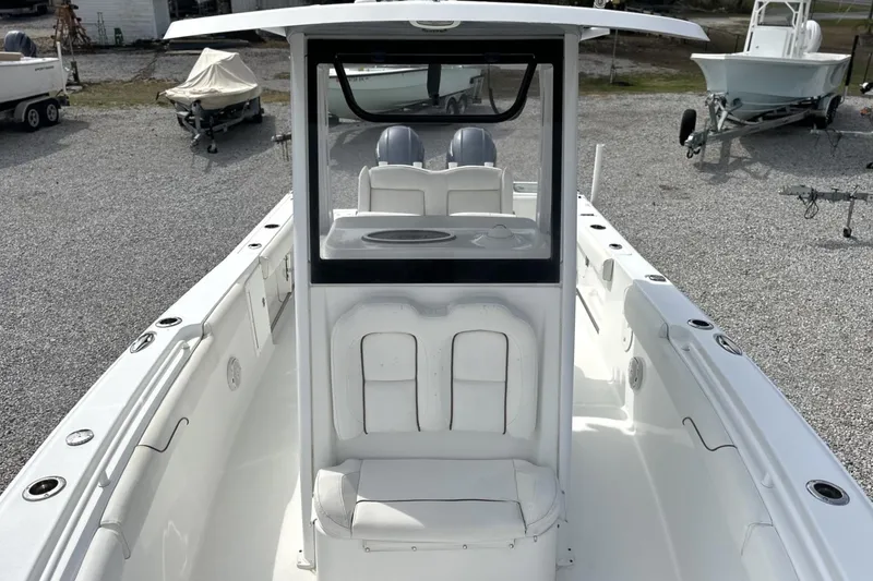Slide: The Image of 2018 Sea Hunt Gamefish 27 Forward Seating boat, white interior, docked on gravel. - 16