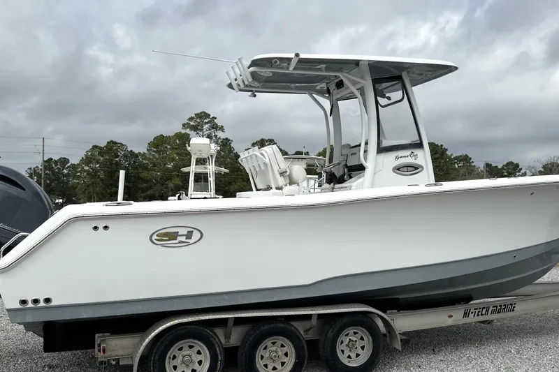 Slide: The Image of 2018 Sea Hunt Gamefish 27 boat on trailer, side view, cloudy sky background. - 2
