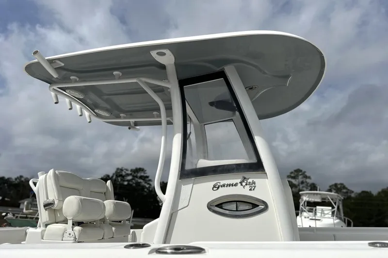 Slide: The Image of 2018 Sea Hunt Gamefish 27 boat with forward seating and T-top under cloudy sky. - 3