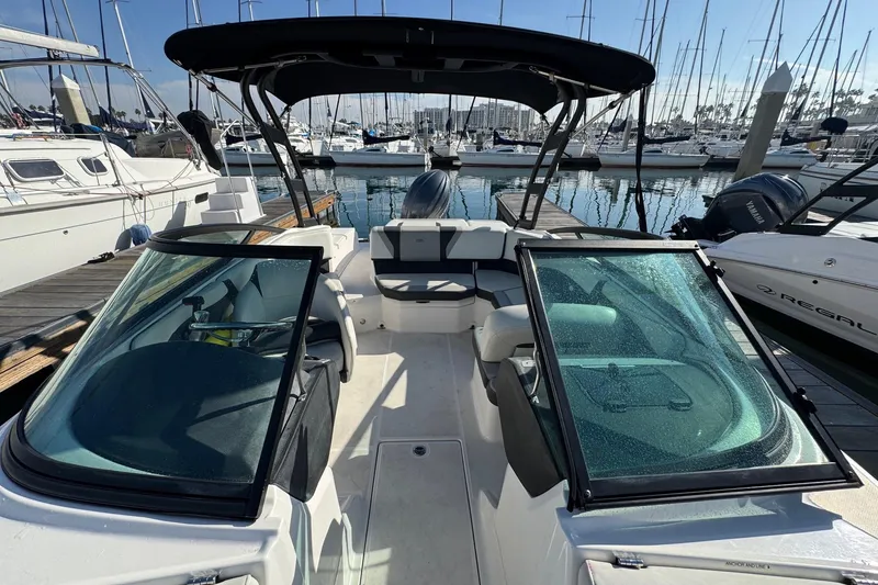 Slide: The Image of 2024 Regal 21 OBX boat docked at marina, featuring sleek design and spacious seating. - 11