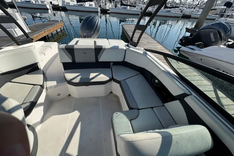 Slide: The Image of 2024 Regal 21 OBX boat interior with spacious seating at a marina. - 12