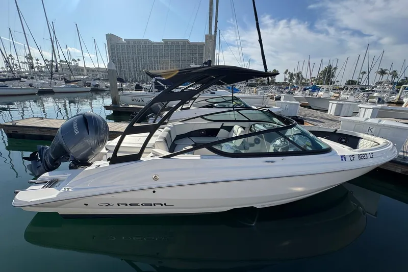 Slide: The Image of 2024 Regal 21 OBX boat docked at marina, featuring sleek design and Yamaha outboard motor. - 3