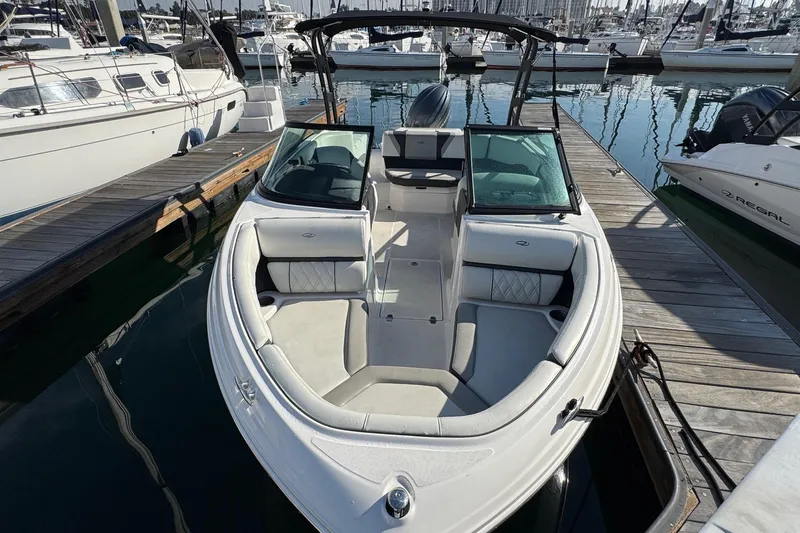Slide: The Image of 2024 Regal 21 OBX boat docked at marina, showcasing sleek design and spacious seating. - 5
