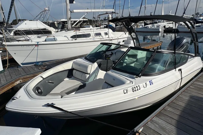 Slide: The Image of 2024 Regal 21 OBX boat docked at marina, surrounded by sailboats. - 6