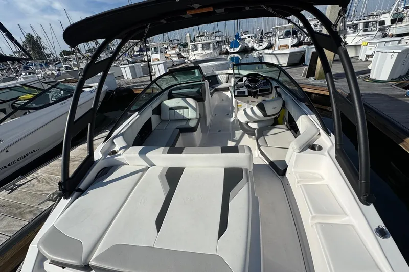 Slide: The Image of 2024 Regal 21 OBX boat interior at marina, showcasing seating and steering area. - 9