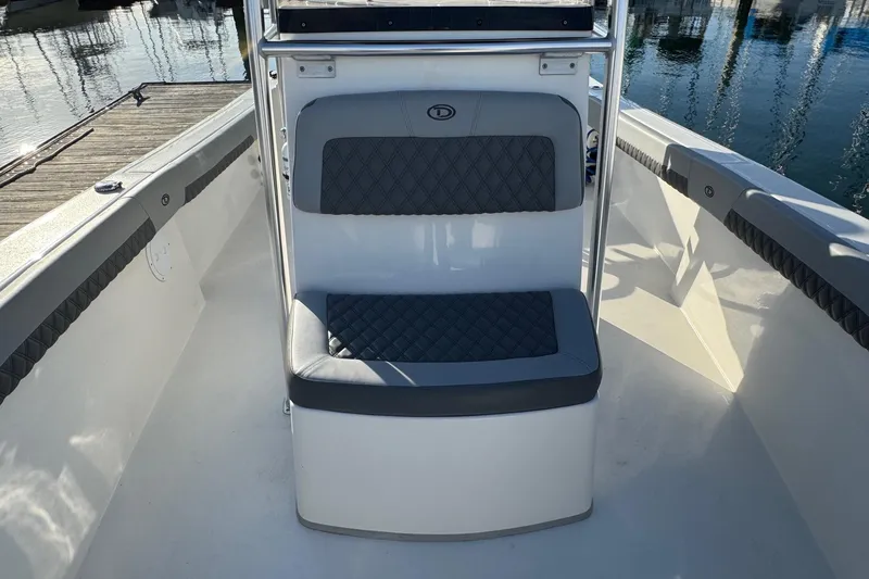 Slide: The Image of 2025 Defiance Catalina 240 boat interior with cushioned seating, dockside view. - 18