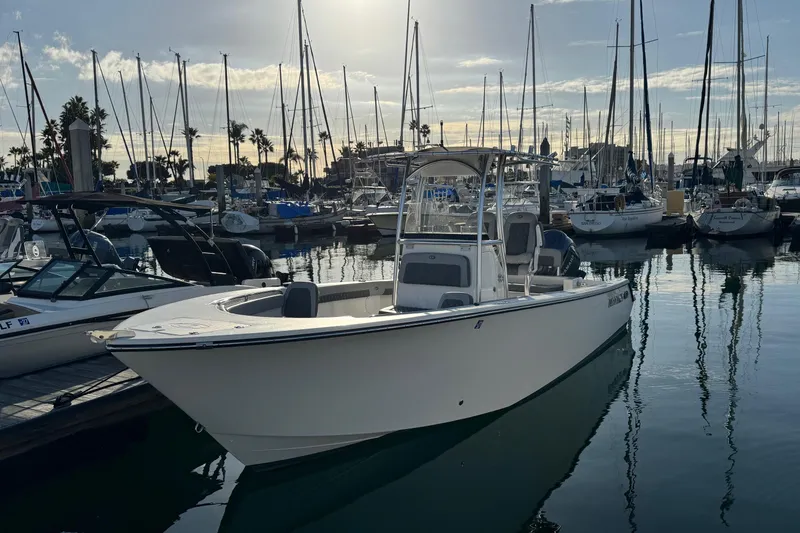 Slide: The Image of 2025 Defiance Catalina 240 boat docked in a marina with sailboats in the background. - 2