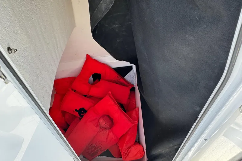 Slide: The Image of Red life jackets stored in a compartment of a 2025 Defiance Catalina 240 boat. - 22
