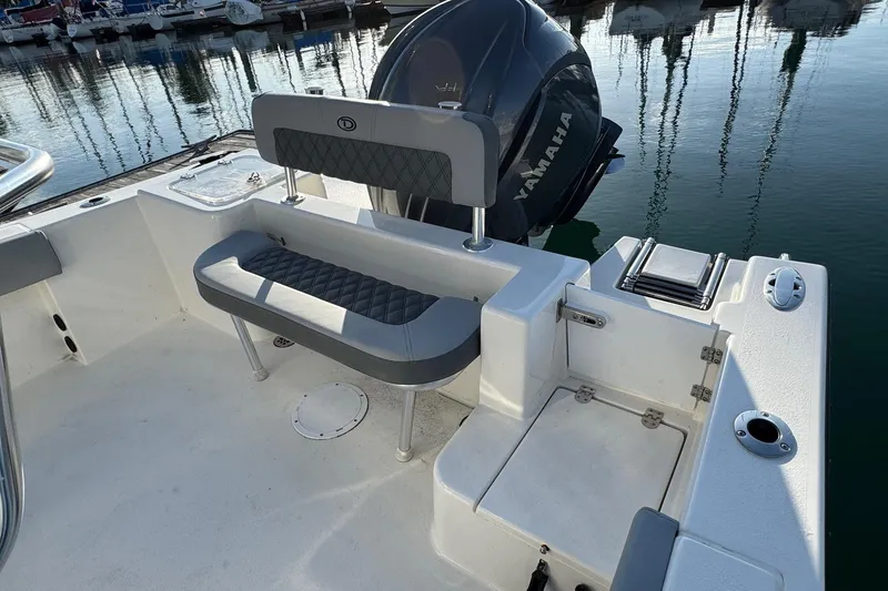 Slide: The Image of 2025 Defiance Catalina 240 boat interior with seating and Yamaha engine at marina. - 32
