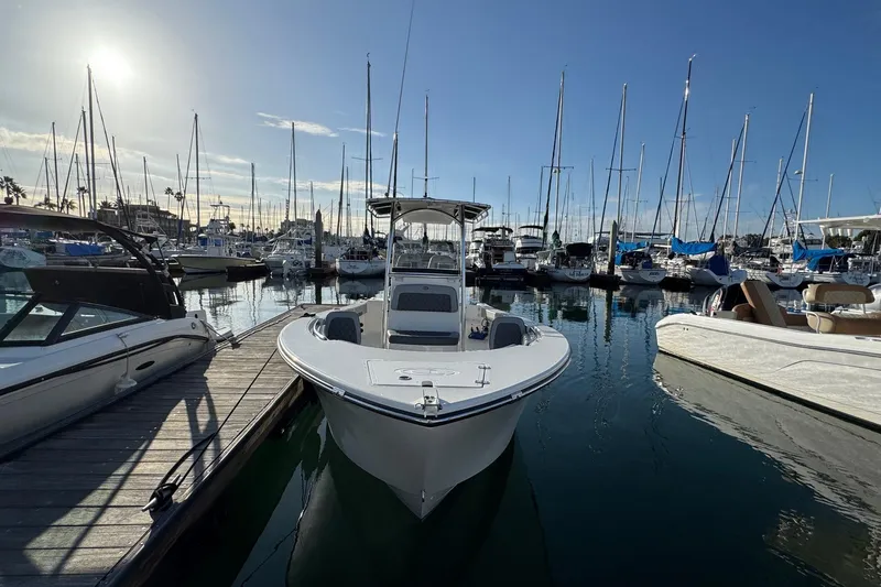 Slide: The Image of 2025 Defiance Catalina 240 boat docked in a marina under a clear blue sky. - 8