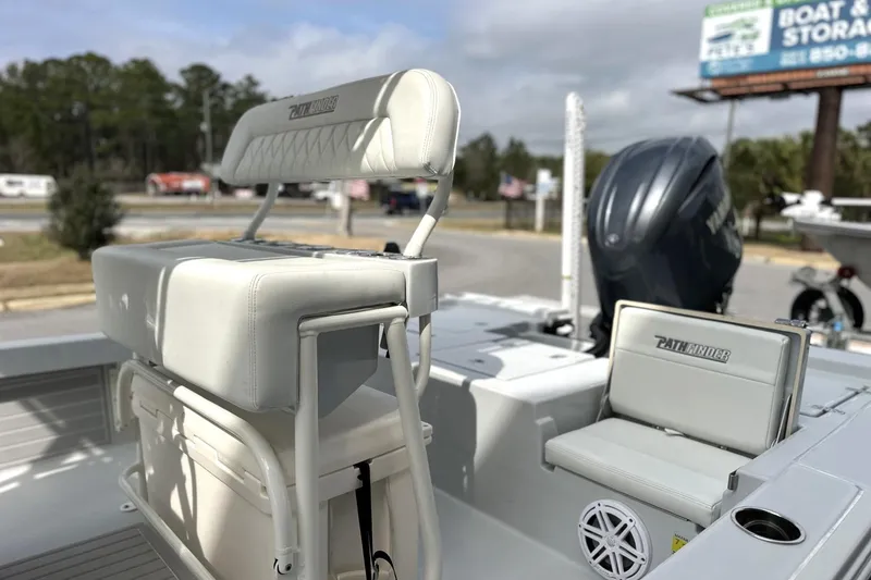 Slide: The Image of 2024 Pathfinder 2200 TRS boat interior with seating and motor, parked outdoors. - 10