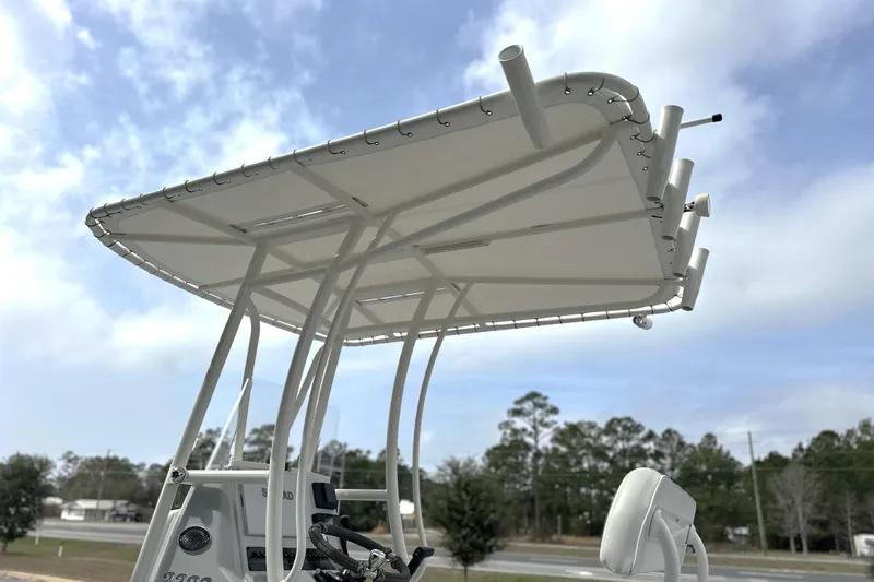 Slide: The Image of 2024 Pathfinder 2200 TRS boat with T-top and rod holders against a cloudy sky. - 8