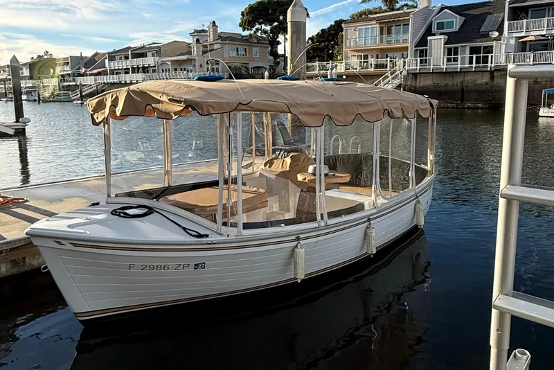 The Image of 2022 Duffy 16 electric boat docked in a scenic marina setting. - 0