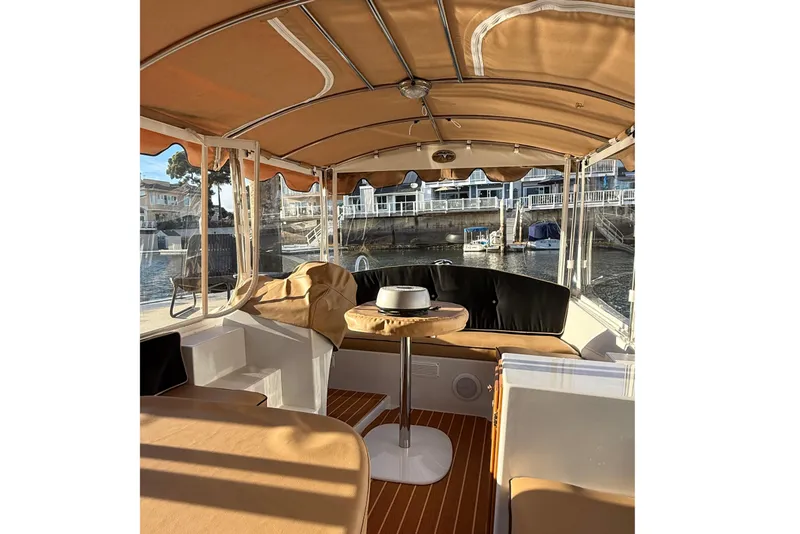 Slide: The Image of Interior of a 2022 Duffy 16 boat with tan canopy and seating. - 11