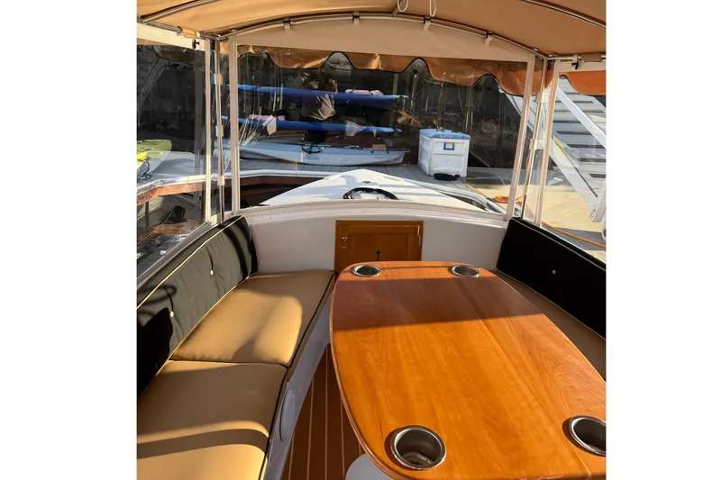 Slide: The Image of Interior of 2022 Duffy 16 boat with cushioned seating and wooden table. - 12