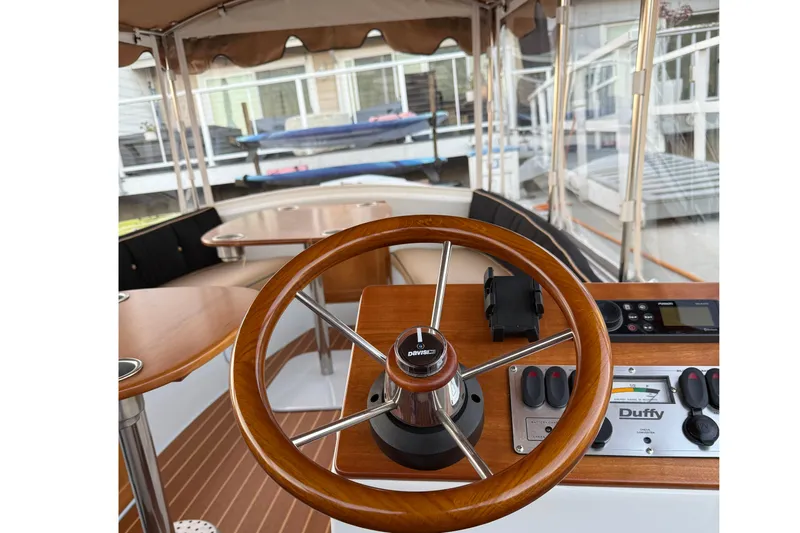Slide: The Image of 2022 Duffy 16 boat interior with wooden steering wheel and control panel. - 9