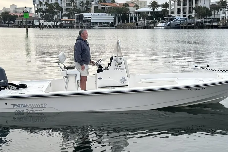 The Image of Man on 2012 Pathfinder 2200 Tournament Edition boat in calm waters near marina. - 1