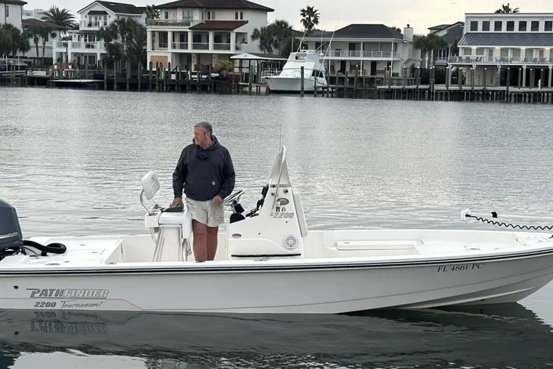 Slide: The Image of Man on 2012 Pathfinder 2200 Tournament Edition boat in a calm waterfront setting. - 2