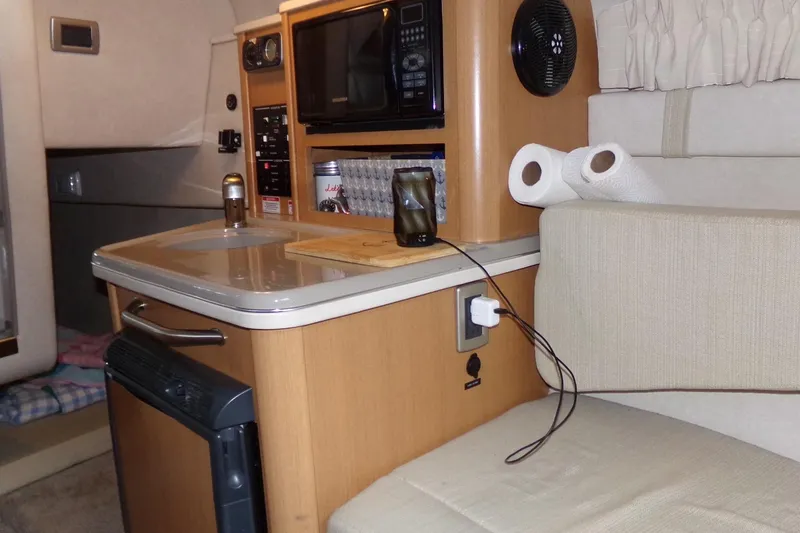 Slide: The Image of 2009 Searay Sundancer cabin interior with kitchenette, featuring microwave and sink. - 13