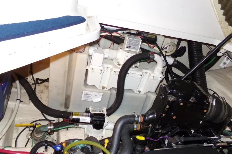Slide: The Image of Engine compartment of a 2009 Searay Sundancer boat, showing various mechanical components and hoses. - 19