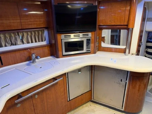 Slide: The Image of Interior of Sea Ray 420 Sundancer yacht, kitchen with wood cabinets and appliances. - 17
