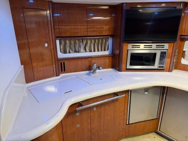 Slide: The Image of Sea Ray 420 Sundancer 2004 kitchen area with wood cabinets and appliances. - 27