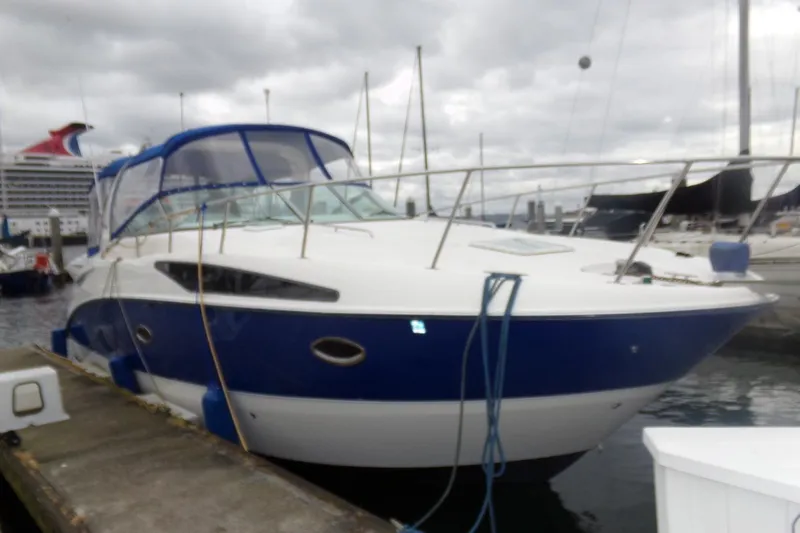 Slide: The Image of 2006 Bayliner 325 boat docked at marina, featuring blue and white exterior. - 13