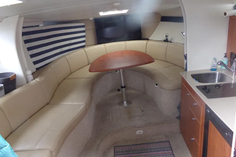 Slide: The Image of Interior of 2006 Bayliner 325 boat with beige seating, table, and kitchenette. - 17