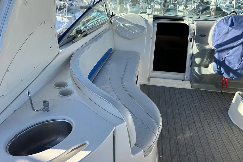 Slide: The Image of 2006 Bayliner 325 boat interior with seating, sink, and open cabin door. - 21