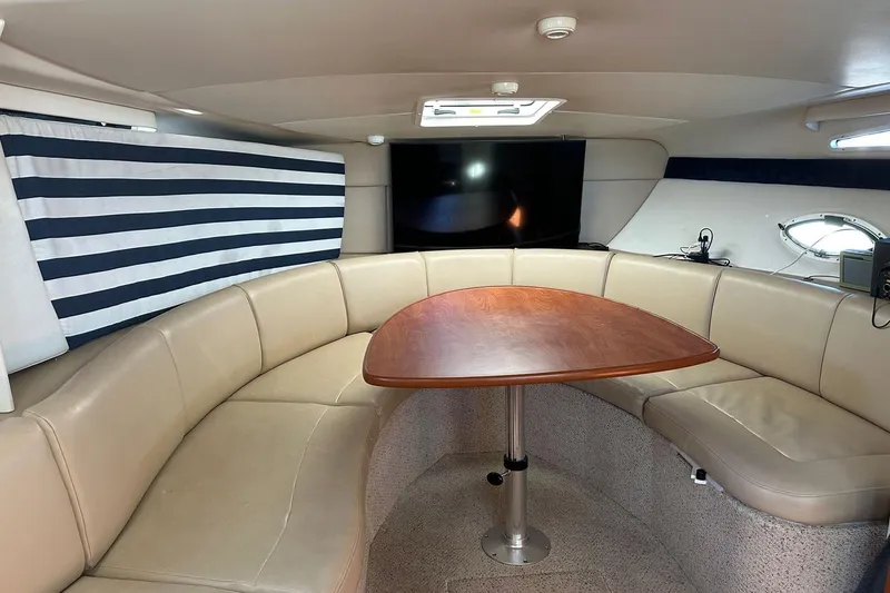 Slide: The Image of Interior of 2006 Bayliner 325 yacht with beige seating and wooden table. - 25
