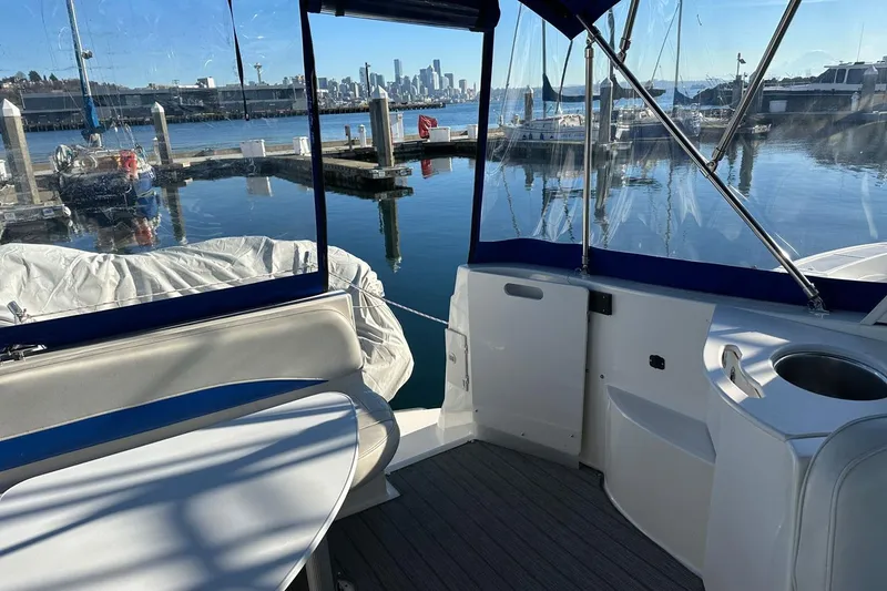 Slide: The Image of 2006 Bayliner 325 boat interior with marina view and city skyline in the background. - 26