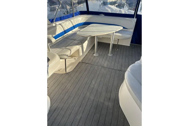 Slide: The Image of 2006 Bayliner 325 boat interior with seating and table, featuring blue accents. - 27