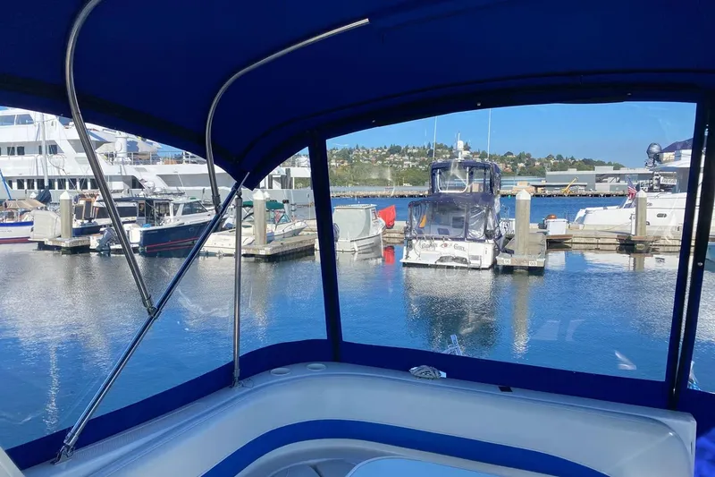 Slide: The Image of 2006 Bayliner 325 boat interior view at marina, surrounded by yachts and calm water. - 29