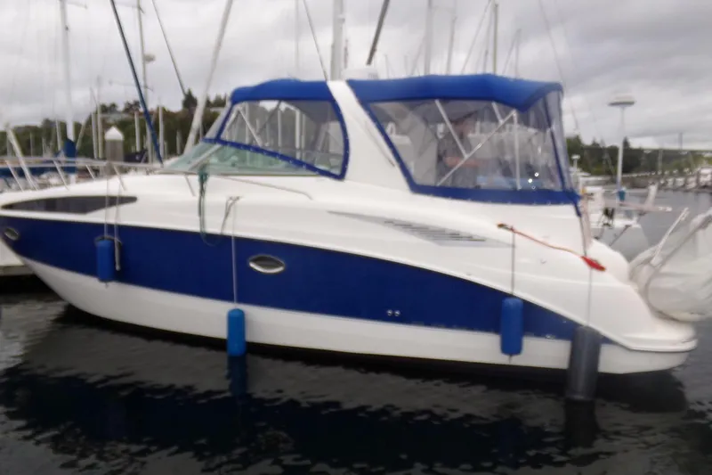 Slide: The Image of 2006 Bayliner 325 boat docked in a marina with blue and white exterior. - 3