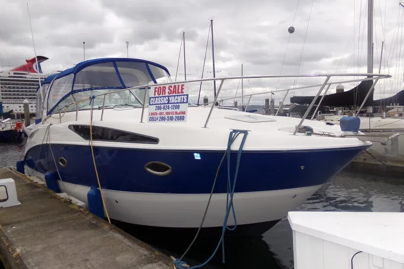 Slide: The Image of 2006 Bayliner 325 yacht for sale at marina, featuring blue and white exterior. - 5