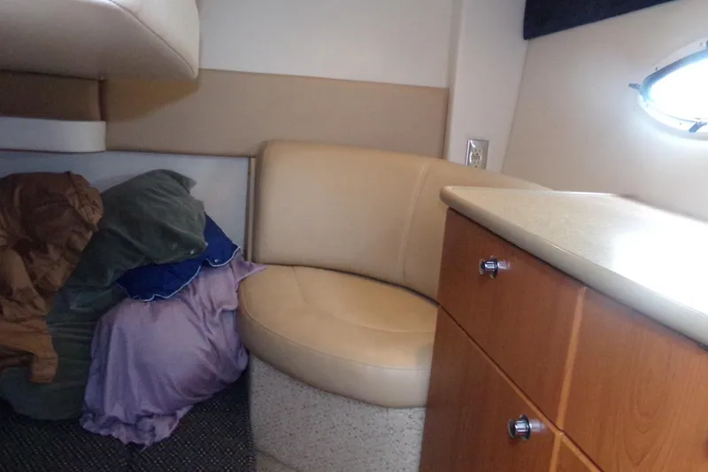 Slide: The Image of Interior of 2006 Bayliner 325 boat with seating, cushions, and wooden cabinetry. - 6