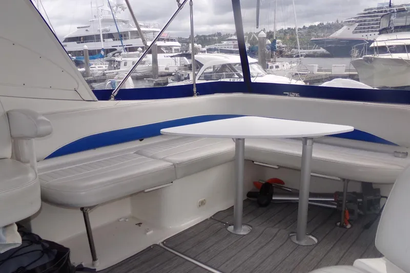 Slide: The Image of 2006 Bayliner 325 boat interior with seating and table, docked at marina. - 7