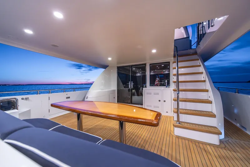Slide: The Image of Luxurious 2013 Ocean Alexander 72 Pilothouse yacht deck at sunset, featuring elegant seating and stairs. - 16
