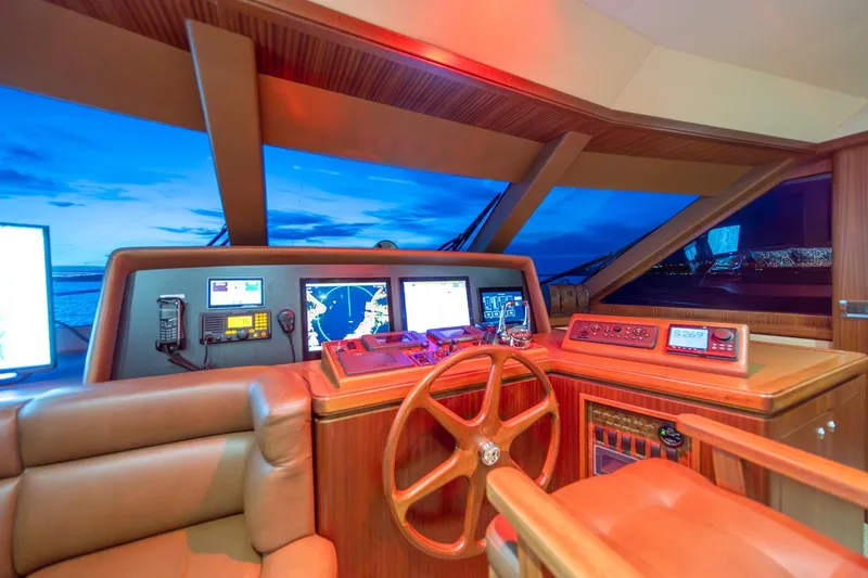 Slide: The Image of Pilothouse interior of 2013 Ocean Alexander 72, featuring navigation equipment and wooden steering wheel. - 26