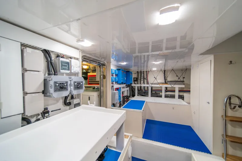 Slide: The Image of Engine room of 2013 Ocean Alexander 72 Pilothouse yacht, featuring modern equipment and blue flooring. - 43