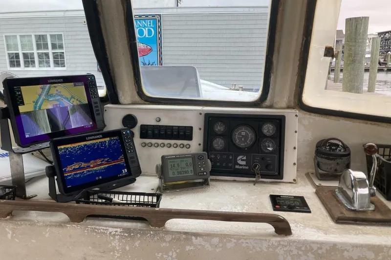 Slide: The Image of Boat cockpit with navigation equipment, including Lowrance displays and marine controls, BGM Custom 1986. - 31