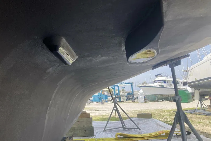 Slide: The Image of Underneath view of a 1986 BGM Custom boat hull in a marina setting. - 32