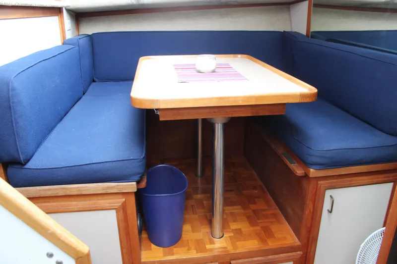 Slide: The Image of 1987 Carver 36 Aft Cabin Motor Yacht interior with blue seating and wooden table. - 21