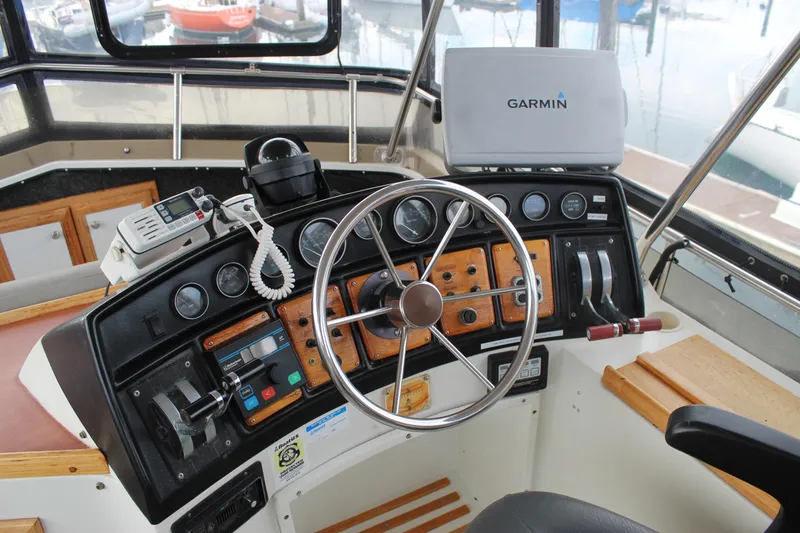 Slide: The Image of 1987 Carver 36 Aft Cabin Motor Yacht helm with Garmin navigation system and classic controls. - 8