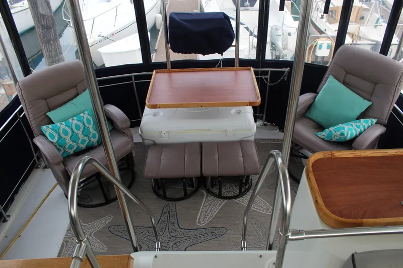 Slide: The Image of 1987 Carver 36 Aft Cabin Motor Yacht interior with seating and table, featuring nautical decor. - 12
