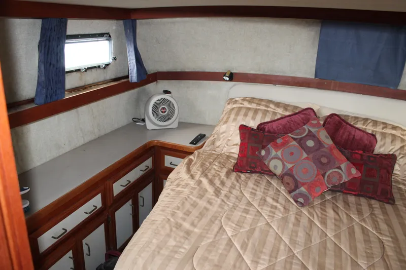 Slide: The Image of 1987 Carver 36 Aft Cabin Motor Yacht bedroom with cozy bedding and decorative pillows. - 25
