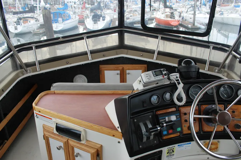 Slide: The Image of 1987 Carver 36 Aft Cabin Motor Yacht helm with marina view, featuring navigation instruments. - 9