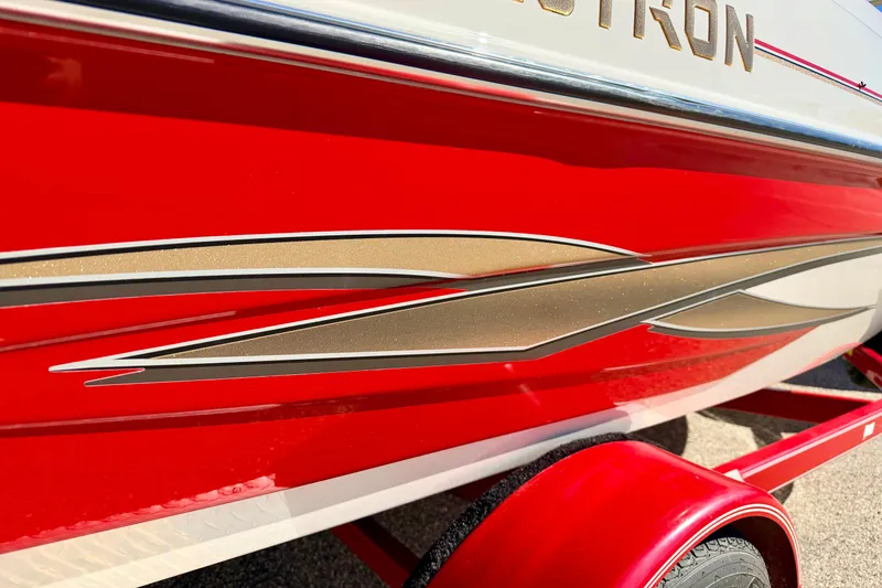 Slide: The Image of 2003 Glastron/Carlson GX180 boat with red and gold detailing on trailer. - 10