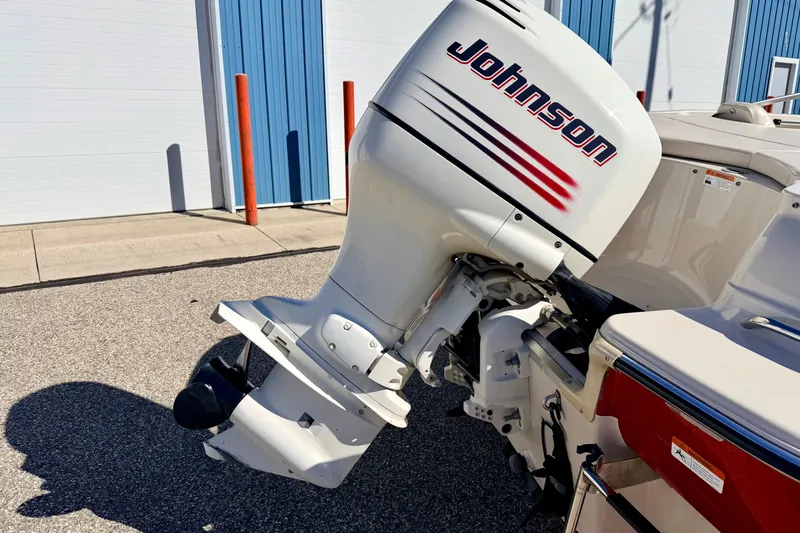 Slide: The Image of 2003 Glastron/Carlson GX180 boat with Johnson outboard motor, parked near blue building. - 12